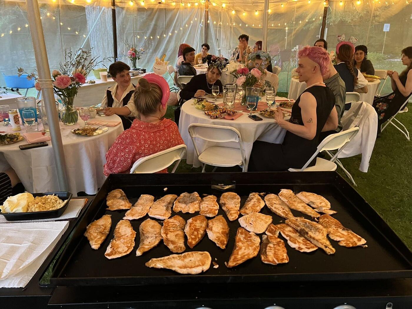 Hibachi chicken cooking on the grill at a Long Island tent party