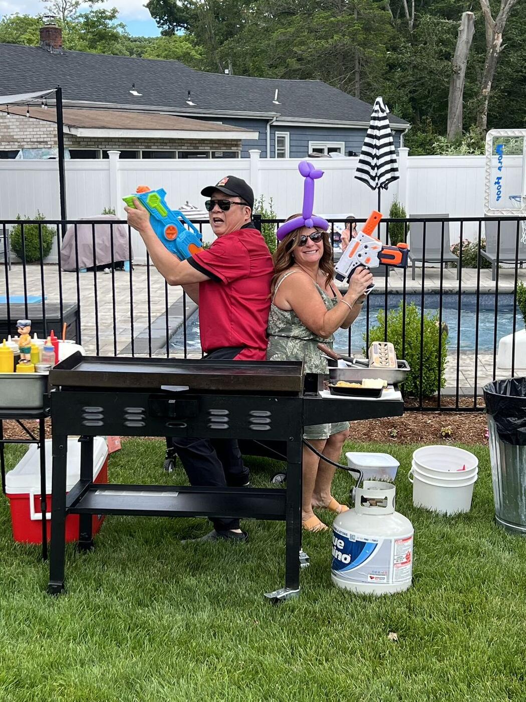 Happy Hibachi chef with guests at a Long Island pool backyard party